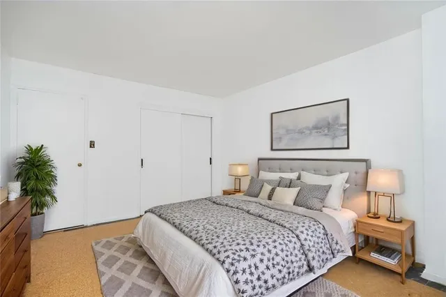 a bedroom with a bed and a potted plant