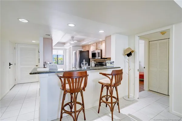 a kitchen with stainless steel appliances kitchen island granite countertop a refrigerator and a stove top oven