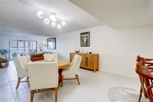 a living room with furniture a chandelier and a dining table