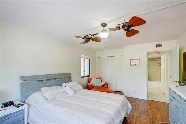 a bedroom with a bed and wooden floor