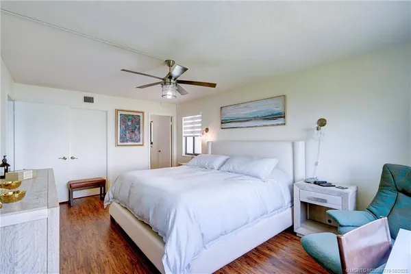 a bedroom with a large bed a chandelier and a window