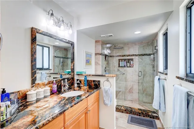 a bathroom with double vanity and a shower