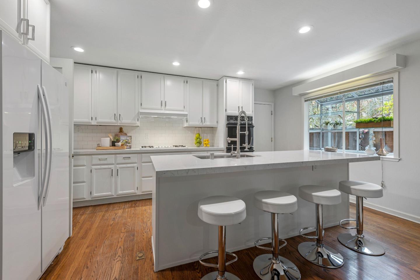 360 Iris Way Palo Alto, CA 94303 - Photo 9 of 28 a kitchen with a table chairs refrigerator and cabinets