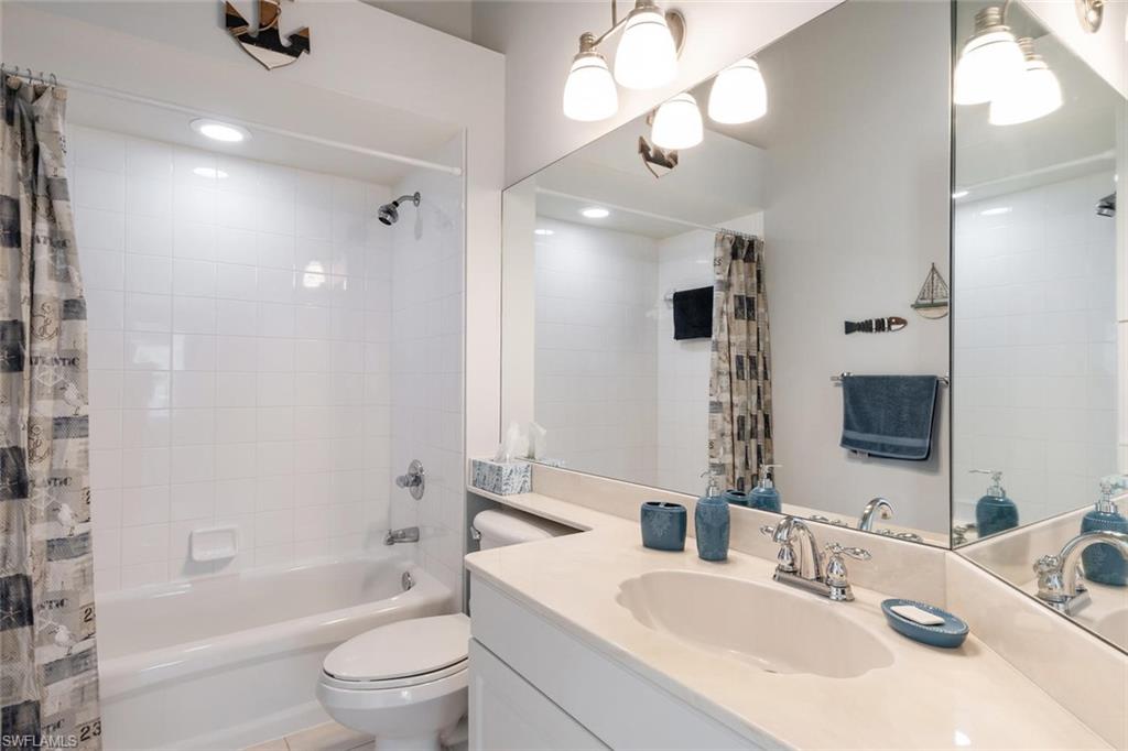 8449 Indian Wells Way Naples, FL 34113 - Photo 18 of 35 a bathroom with a sink a toilet a mirror and shower