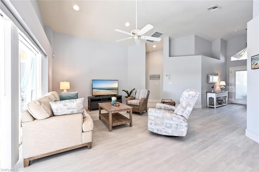 8449 Indian Wells Way Naples, FL 34113 - Photo 35 of 35 a living room with furniture and a chandelier