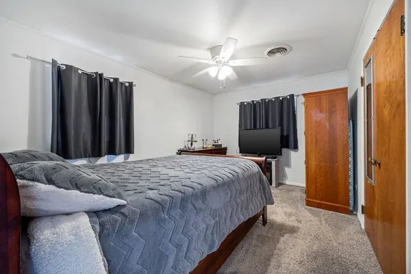 a bedroom with a bed dresser and a window