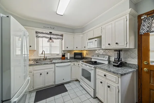 a kitchen with stainless steel appliances granite countertop a sink stove and cabinets