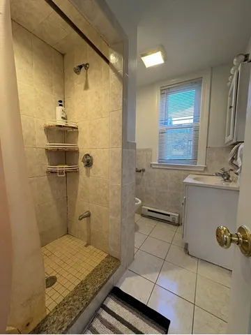 a bathroom with a granite countertop sink a toilet and shower