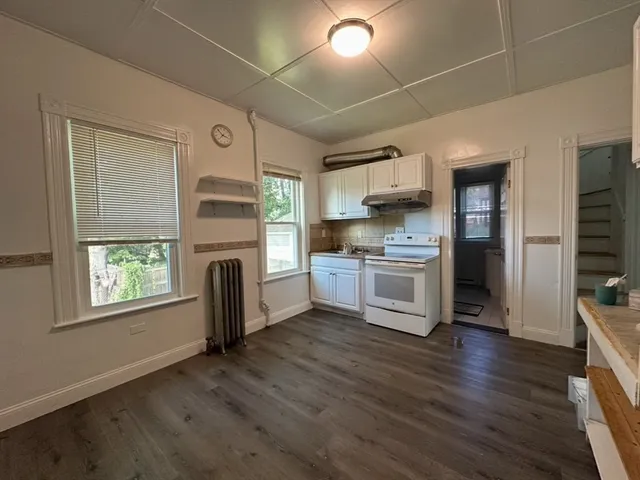a kitchen with stainless steel appliances a white cabinets and a wooden floor