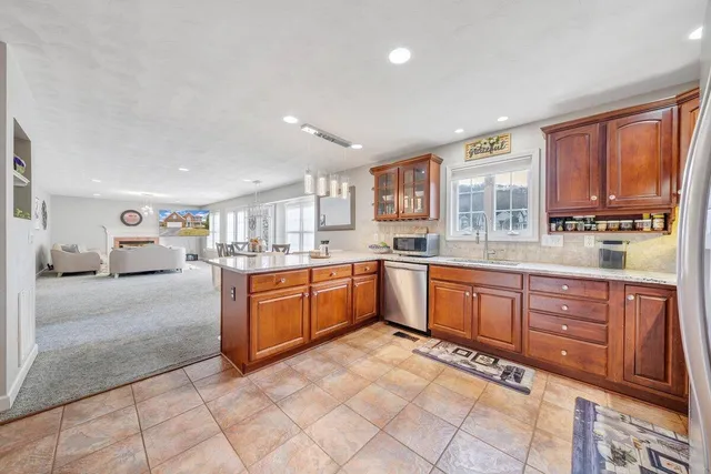 a large kitchen with stainless steel appliances granite countertop a stove sink and cabinets