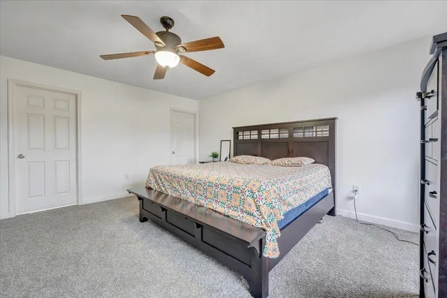 a spacious bedroom with a bed and a chandelier