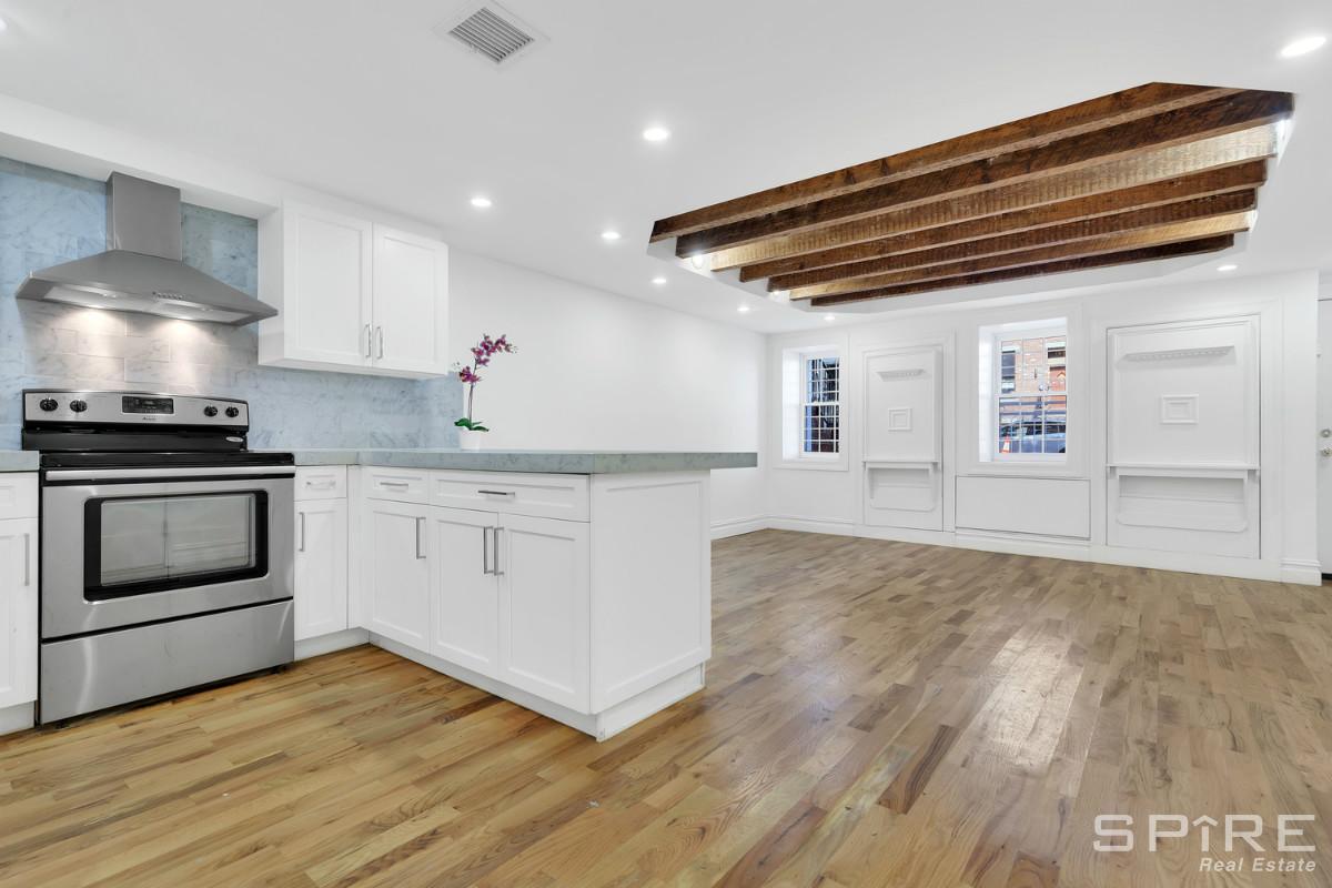 1070 Hancock Street, Unit 1 Brooklyn, NY 11221 - Photo 1 of 1 a kitchen with granite countertop a stove cabinets and wooden floor