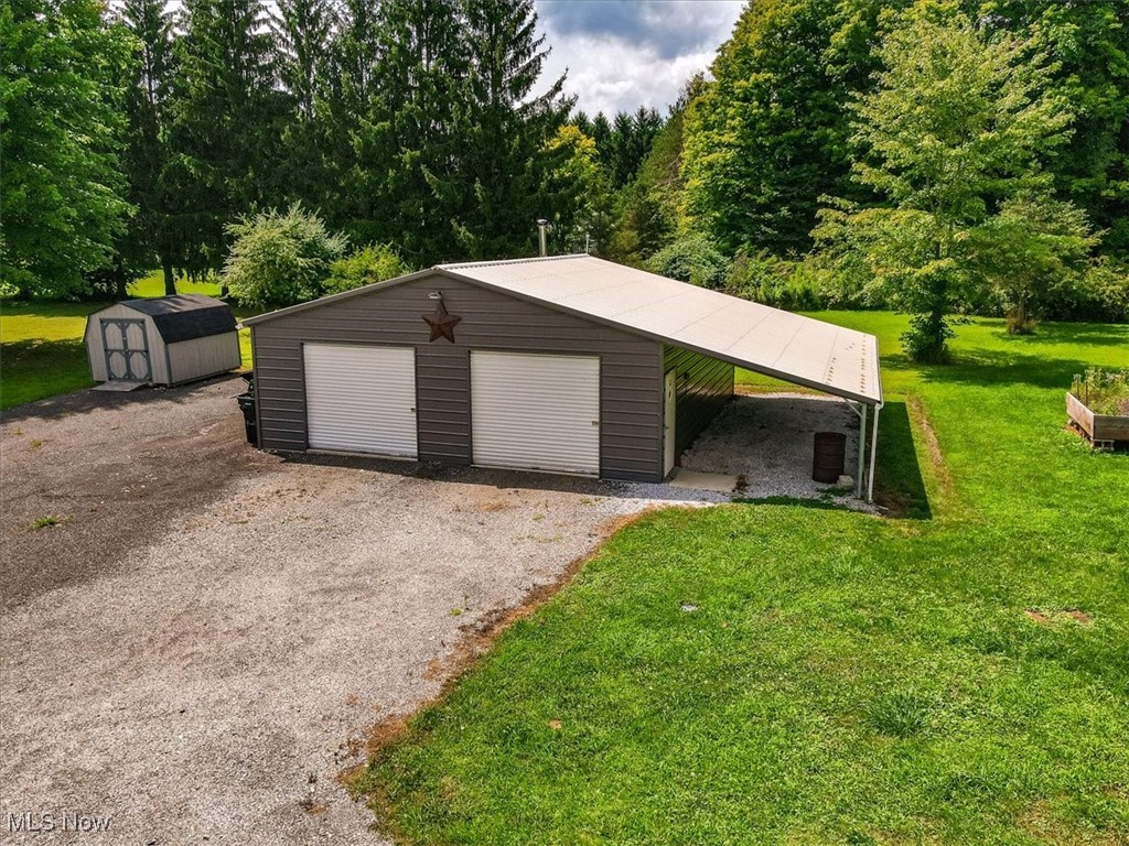 5525 White Road Geneva, OH 44041 - Photo 5 of 28 Garage with a lawn and a carport