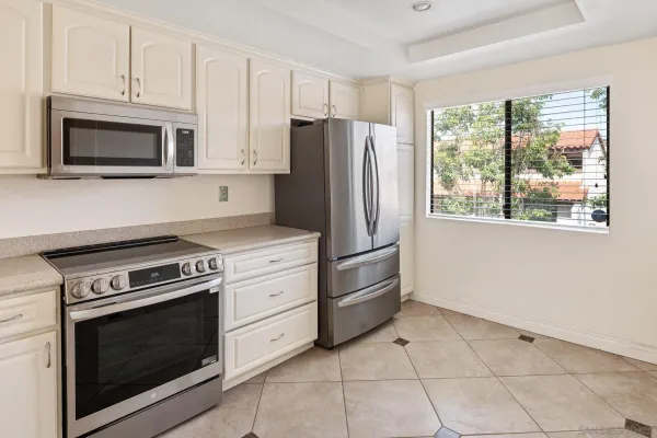 a kitchen with cabinets stainless steel appliances and a window