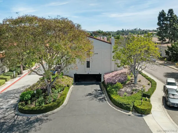an aerial view of a house with a garden and lake view