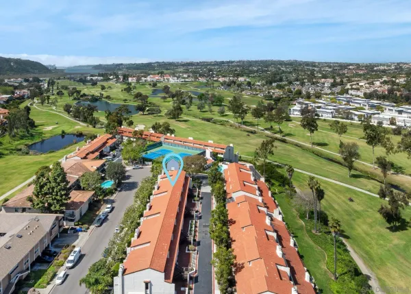 an aerial view of residential houses with outdoor space and lake view