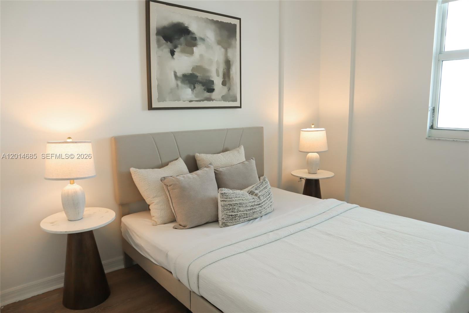 9172 Collins Avenue, Unit 212 Surfside, FL 33154 - Photo 5 of 23 a bedroom with a bed and a lamp on table