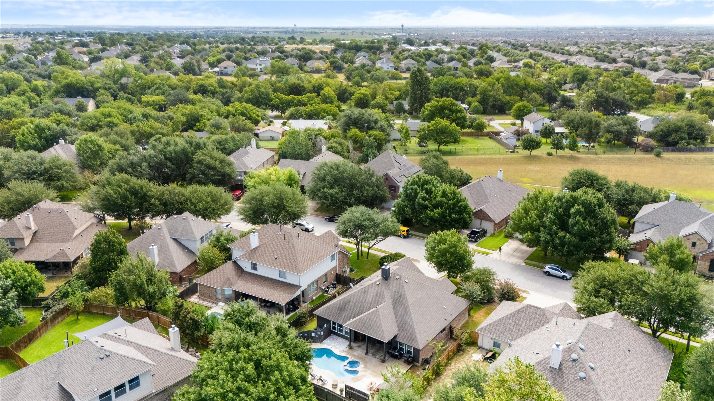 20704 Windmill Ridge Street Pflugerville, TX 78660 - Photo 30 of 34 An aerial perspective reveals a vibrant neighborhood with ample green space and a private pool beckoning outdoor enjoyment.