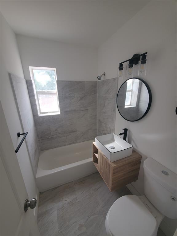74 Northwest 31st Street, Unit 1 Miami, FL 33127 - Photo 14 of 14 a bathroom with a toilet sink vanity tub and mirror
