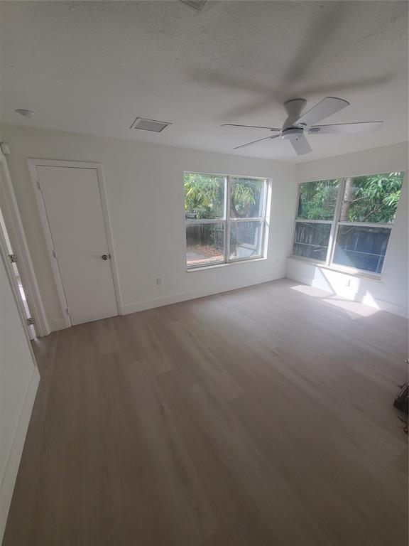74 Northwest 31st Street, Unit 1 Miami, FL 33127 - Photo 3 of 14 an empty room with a fireplace and large windows