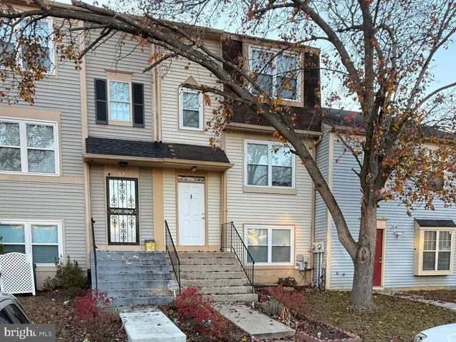 a front view of a house with a tree