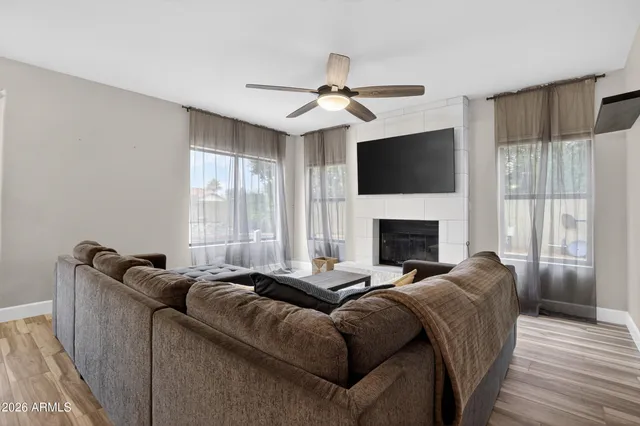 a living room with furniture ceiling fan and a fireplace