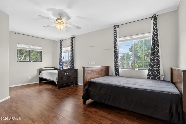a bedroom with a bed a window and wooden floor