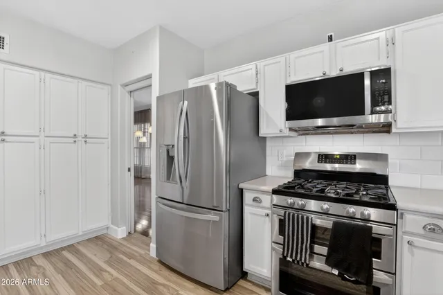 a kitchen with appliances a sink and cabinets