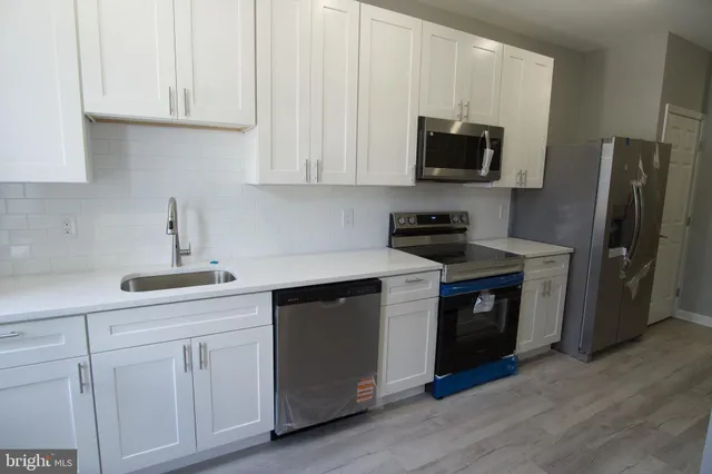 a kitchen with white cabinets and stainless steel appliances