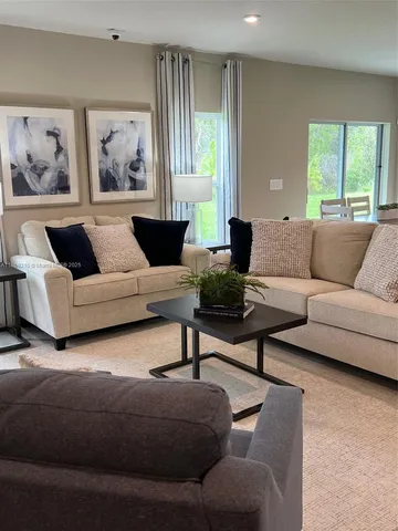 a living room with a couch and a view of kitchen