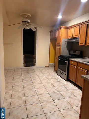 a kitchen with stainless steel appliances kitchen island granite countertop a refrigerator and a sink