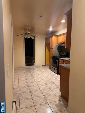a room with a black white checkered floor with kitchen view
