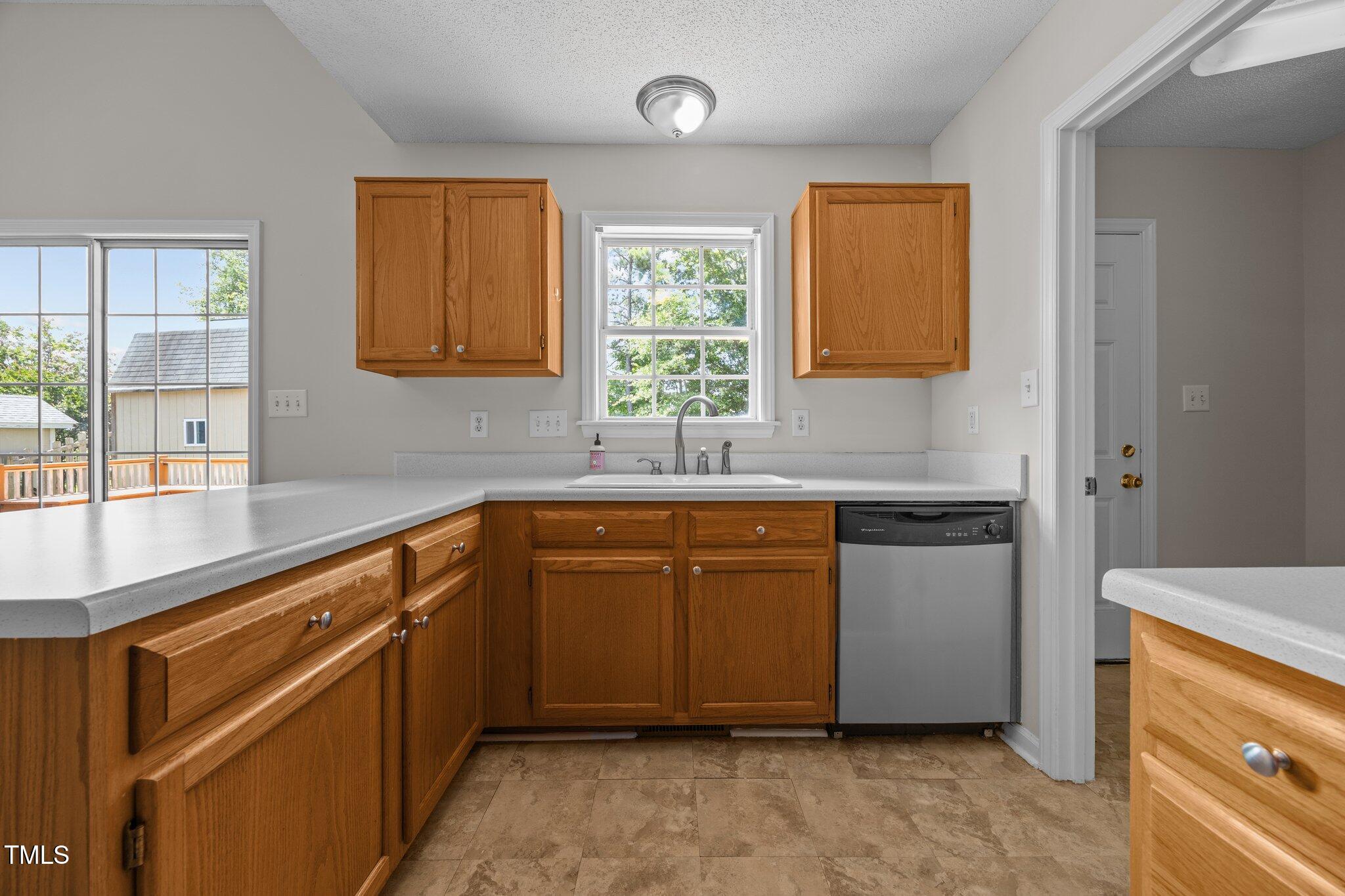 408 Flagg Road Holly Springs, NC 27540 - Photo 13 of 32 a kitchen with granite countertop a sink and a stove next to a window
