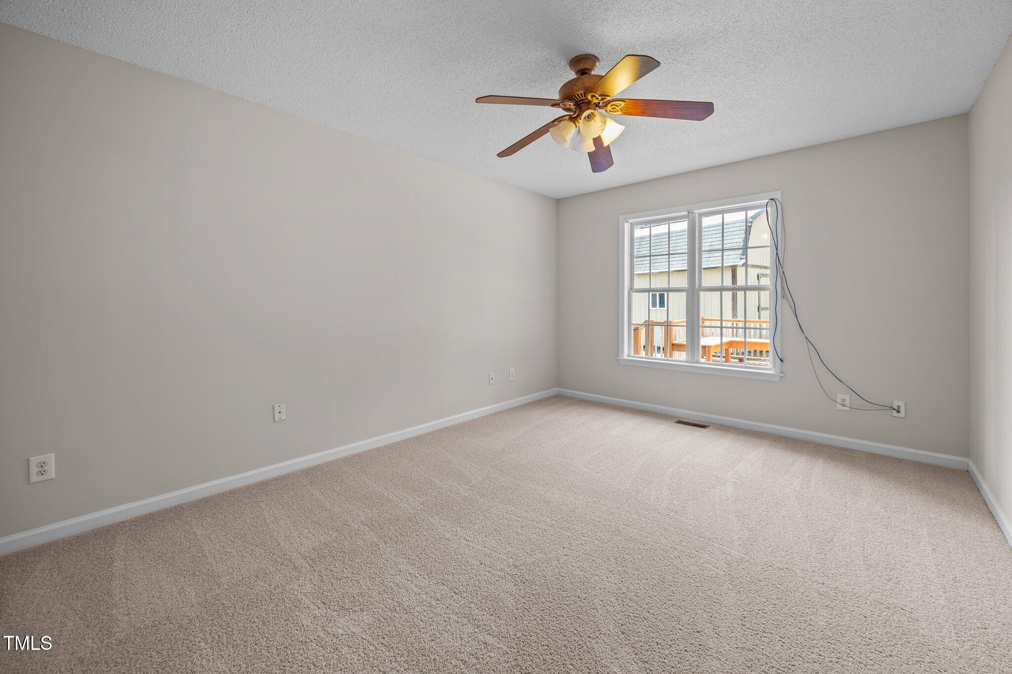 408 Flagg Road Holly Springs, NC 27540 - Photo 16 of 32 an empty room with chandelier fan and windows