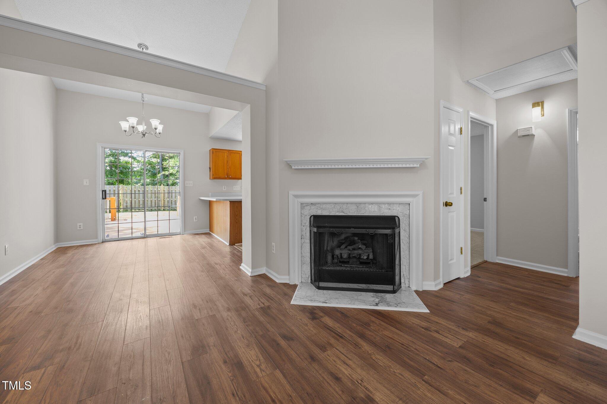 408 Flagg Road Holly Springs, NC 27540 - Photo 4 of 32 a view of an empty room with wooden floor fireplace and a window