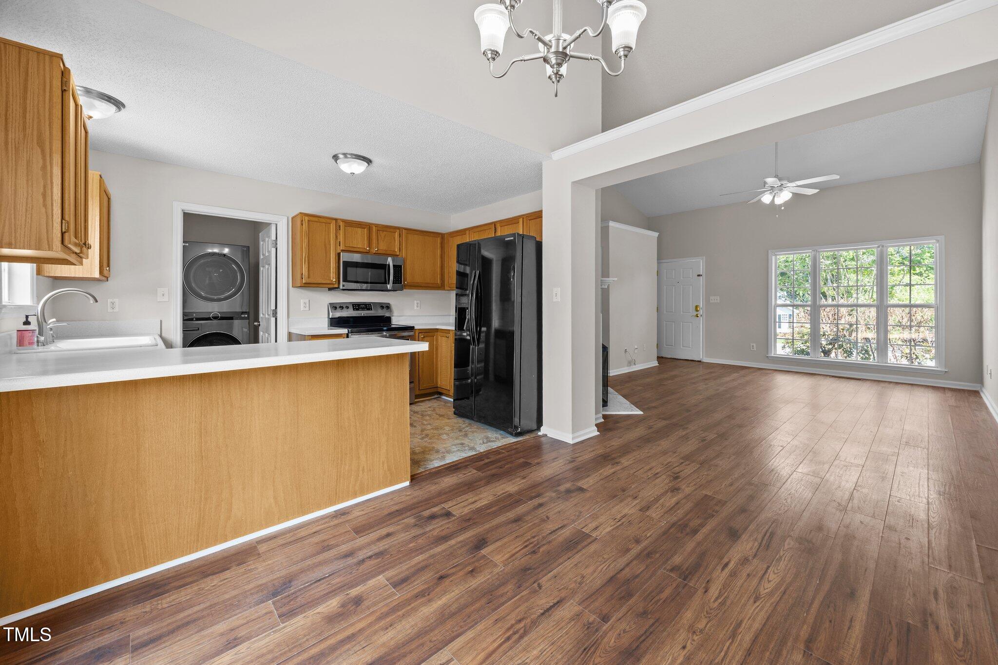 408 Flagg Road Holly Springs, NC 27540 - Photo 10 of 32 a kitchen with stainless steel appliances granite countertop a refrigerator a sink dishwasher a stove and a dining table with wooden floor