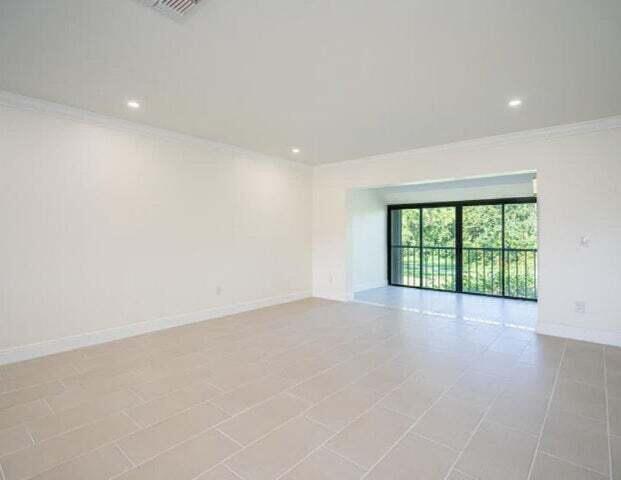 9284 Vista Del Lago, Unit 34F Boca Raton, FL 33428 - Photo 7 of 15 an empty room with wooden floor and windows