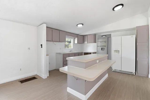 a kitchen with a white cabinets and wooden floor