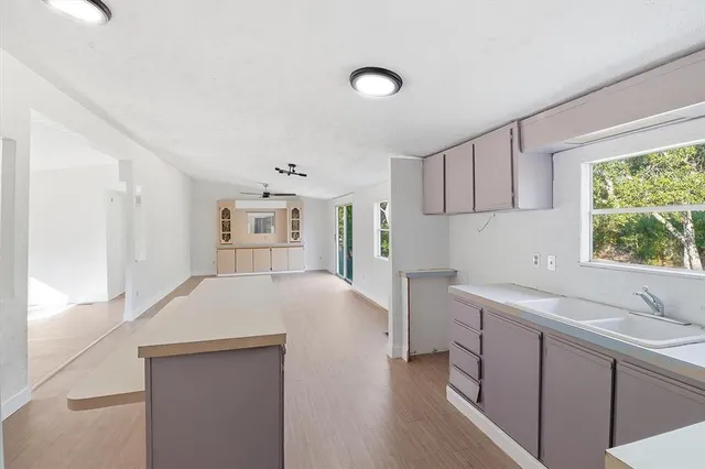 a kitchen with cabinets wooden floor and a sink