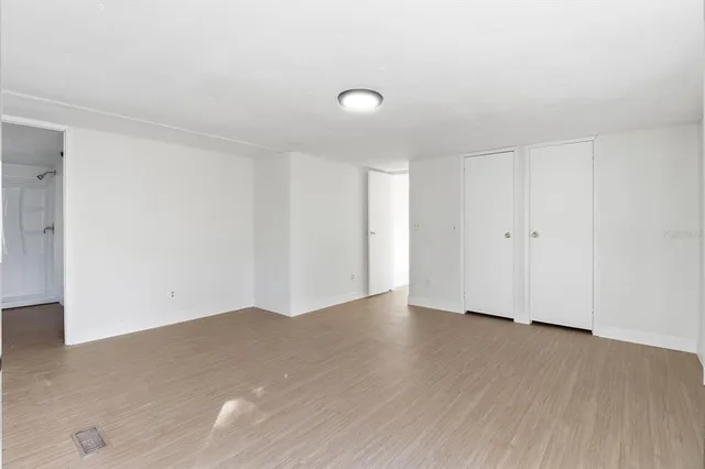 a view of an empty room with wooden floor