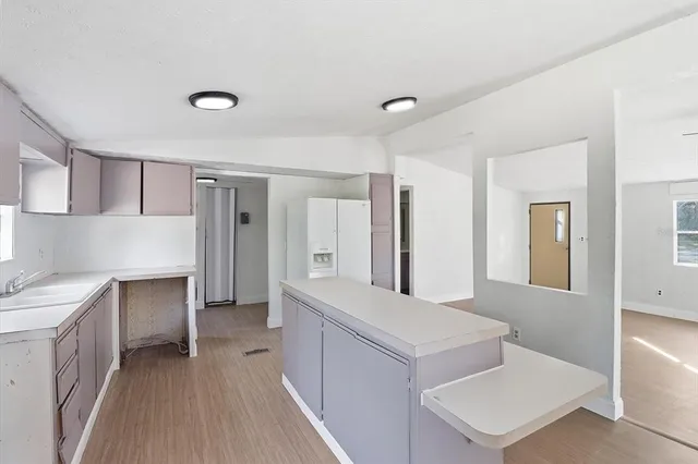 a living room with a sink and a refrigerator