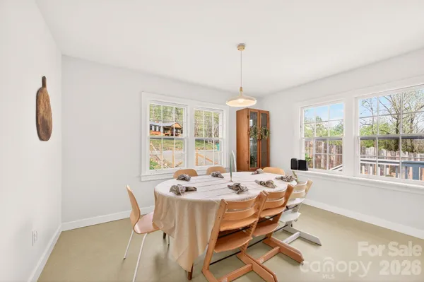 a dining room with furniture large windows and a chandelier