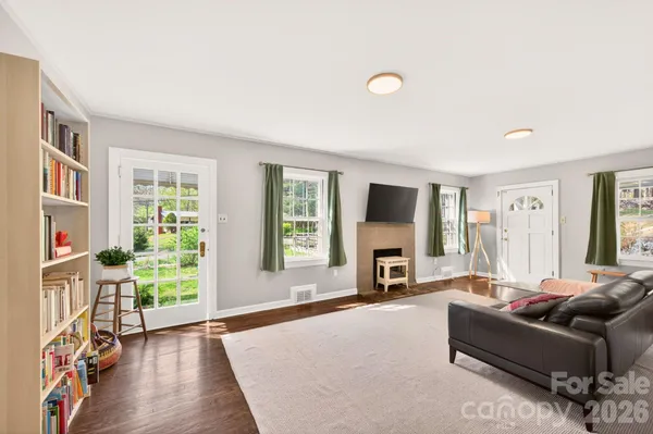 a living room with furniture large window and a fireplace