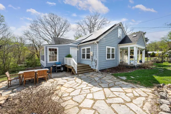 a view of a house with backyard sitting area and garden