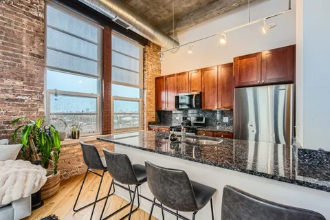 a kitchen with stainless steel appliances granite countertop sink stove and large window