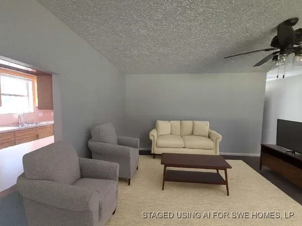 a living room with furniture a flat screen tv and a window