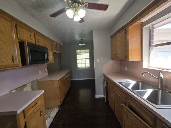 a view of a kitchen with wooden floor and electronic appliances