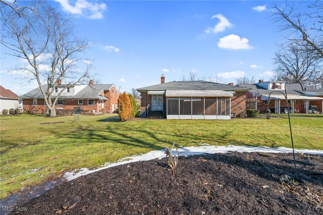 586 Bishop Road Cleveland, OH 44143 - Photo 23 of 24 Rear view of property featuring a sunroom, brick siding, and a lawn