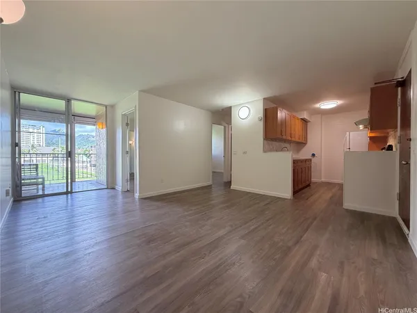 a view of a kitchen with a fridge wooden floor and a window