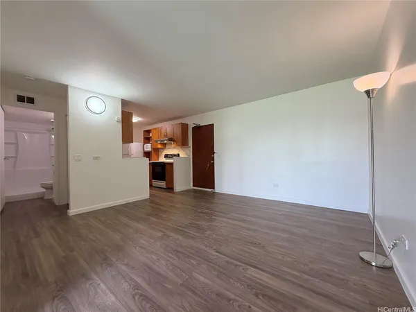 a view of empty room with wooden floor